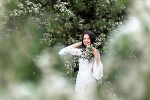 portrait de jeune femme dans le parc dans les branches fleuries photo