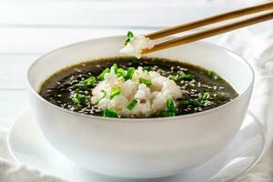 oréen algue crème soupe avec bouilli riz dans une blanc bol. anniversaire soupe. traditionnel coréen cuisine. en bonne santé régime. grossesse. coutume. proche en haut. photo