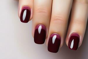 fermer femme main avec Bourgogne rouge clou polonais sur les ongles. Bourgogne clou manucure avec gel polonais à luxe beauté salon. français manucure. clou art et conception. femelle main modèle. génératif ai. photo