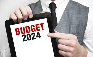 homme d'affaire montrant affaires concept sur tablette permanent dans Bureau budget 2024 photo