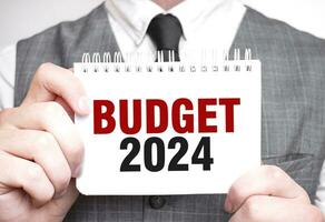 homme d'affaire avec carnet avec texte budget 2024 photo