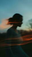 flou image de une femme en marchant par le herbe à le coucher du soleil génératif ai photo