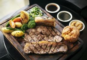 Rôti de boeuf gastronomique du dimanche repas britannique traditionnel sur une vieille table de pub en bois photo