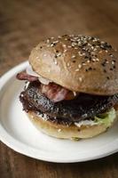 Burger de boeuf bio australien avec du bacon sur fond de table en bois photo