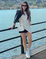 photo de une femme permanent sur une pont par une tranquille rivière