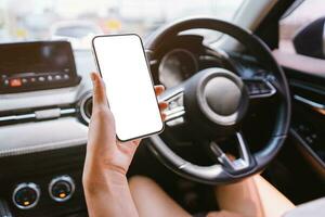 femmes détient une téléphone intelligent avec maquette dans le auto. photo
