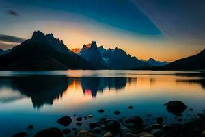 le montagnes sont réfléchi dans le l'eau à le coucher du soleil. généré par ai photo