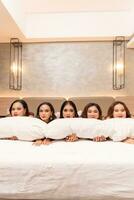 une groupe de asiatique femmes sont en train de dormir et penché sur blanc oreillers avec leur copains dans une luxe Hôtel photo