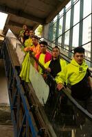 une groupe de asiatique Hommes dans vert chemises doublé en haut sur le escaliers dans un vieux bâtiment photo