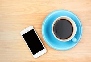 tasse à café bleu et blanc et smartphone avec écran vide photo
