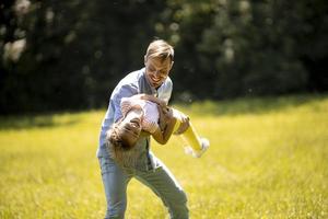 père avec fille s'amusant sur l'herbe au parc