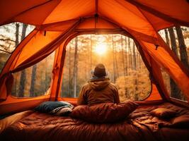 voyageur relaxant à l'intérieur une Orange tente et prendre plaisir avec Matin temps. ai génératif photo