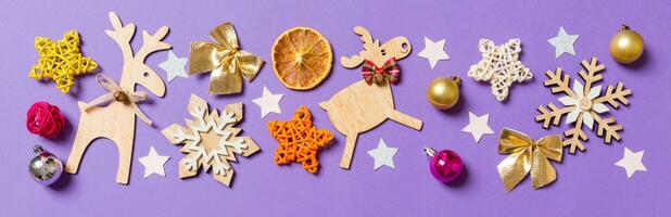 Haut vue bannière de Nouveau année jouets et décorations sur violet Contexte. Noël temps concept avec vide espace pour votre conception photo