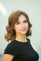 portrait de une magnifique Jeune femme avec longue marron cheveux souriant à le caméra photo