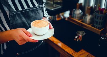 une tasse de café cappuccino menu prêt à servir dans main femme barista dans le café magasin photo