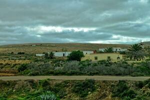 vide mystérieux montagneux paysage de le centre de le canari île Espagnol fuerteventura avec une nuageux ciel photo