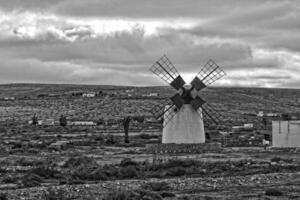 vide mystérieux montagneux paysage de le centre de le canari île Espagnol fuerteventura avec une nuageux ciel et original Moulins à vent photo