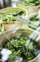 bols de feuilles de laitue verte biologique fraîche dans un bar à salades photo