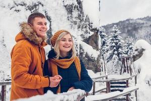 heureux couple d'amoureux marchant dans le parc d'hiver profitant de la neige photo
