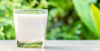 monde Lait jour, verre de blanc Lait sur une en bois bureau, nature, brouiller arrière-plan, proche en haut. content Lait journée. laitier produit concept, copie espace sur droite pour conception ou contenu, personne, monde Lait journée 1 juin photo