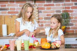 deux peu les filles dans le cuisine avec Frais des légumes. en bonne santé nourriture concept. content sœurs. photo