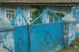 le porte à le maison est décoré avec une modèle de métal. vieux abandonné maison dans le village vieux le fer porte dans le Cour de une pays maison. vert métal portail. photo