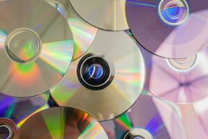 beaucoup vieux CD représenter La technologie de le années 90. piles de CD, vieux Chansons et vieux films. lequel avait été utilisé avant et mis sur une blanc tableau. fermer, sélectif concentrer photo