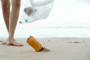 enregistrer océan. bénévole choisir en haut poubelle des ordures à le plage et Plastique bouteilles sont difficile décomposer prévenir nuire aquatique vie. Terre, environnement, écologisation planète, réduire global échauffement, enregistrer monde photo