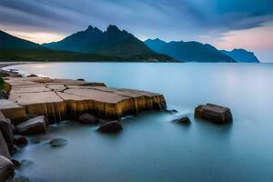 une longue exposition photographier de une rocheux plage et montagnes. généré par ai photo