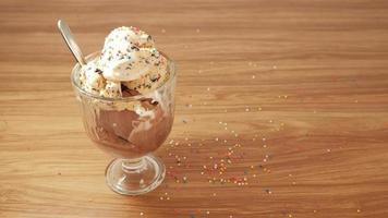 crème glacée aux pépites de chocolat avec garnitures colorées dans des tasses en verre transparent.