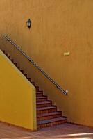 escalier cette pistes en haut à le à l'extérieur de une petit colonial bâtiment photo
