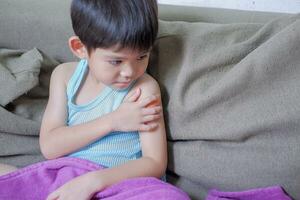 une garçon fait mal le sien bras, en portant le sien bandé bras. photo