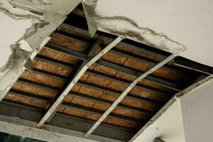 plafond panneaux avait endommagé une grand trou dans le toit de une eau de pluie fuir. plafond endommagé par l'eau. le plafond cassé vers le bas photo