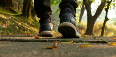 une homme pieds sur le en marchant chemin dans le matin, après certains modifications. photo