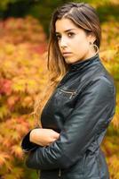 portrait de belle jeune fille avec un fond de feuilles d'automne photo