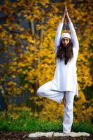 jeune femme lors d'une pratique de yoga dans la nature d'automne photo