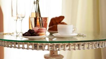 table en verre avec une tasse de café, croissants sucrés