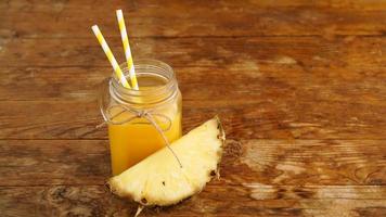 jus d'ananas sur un fond en bois. un bocal en verre avec du jus photo