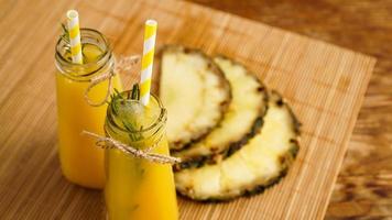 jus d'ananas frais avec de la glace dans une petite bouteille en verre photo