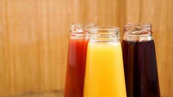 bouteilles en verre de jus de fruits frais et sains sur fond de bois photo