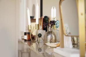décoration intérieure de la maison. bocal en verre avec fleurs séchées, vase et bougie photo