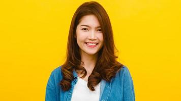 femme asiatique avec une expression positive sur fond jaune. photo