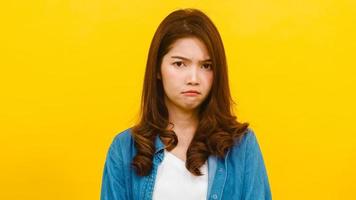 femme asiatique avec une expression négative sur fond jaune. photo