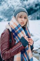Portrait de jeune fille au chapeau avec une écharpe dans les montagnes en hiver photo