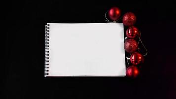 cahier vierge ouvert, boules de noël sur fond noir photo