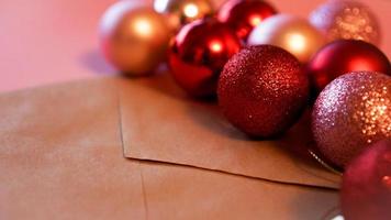 enveloppe de papier kraft avec des boules de noël rouges et roses sur rose photo