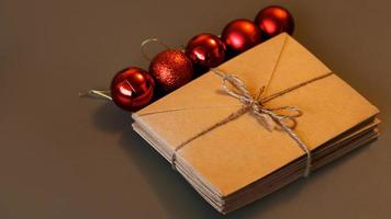 composition de noël. enveloppes artisanales et boules rouges. pile de lettres photo