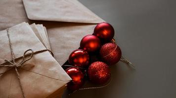 composition de noël. enveloppes artisanales et boules rouges photo