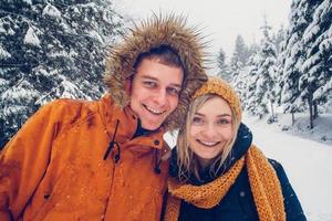 gars et fille marchent et s'amusent dans la forêt en hiver photo
