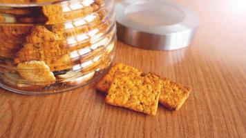 cracker de blé dans un bocal en verre sur une table en bois. photo